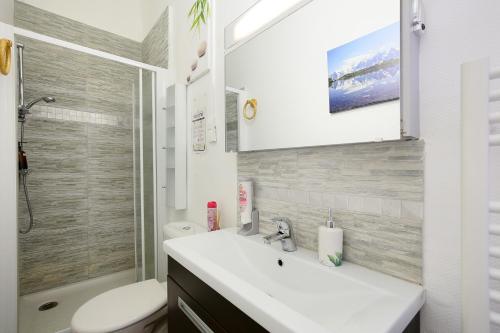 a bathroom with a sink and a toilet and a shower at Le chant de la garonne in Saint-Béat