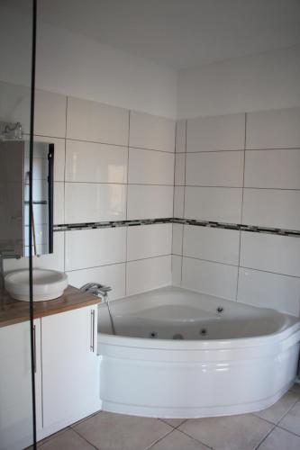 een badkamer met een wit bad en een wastafel bij Les Jasmins in Collioure