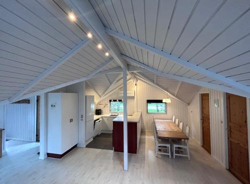a large kitchen with a table and a refrigerator at Sønderborg Wellness Villa in Skovbyballe