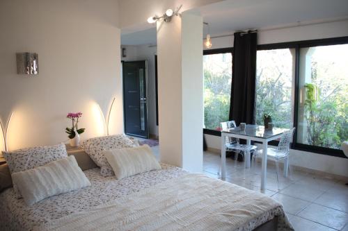 a bedroom with a bed and a dining room with a table at Les Jasmins in Collioure