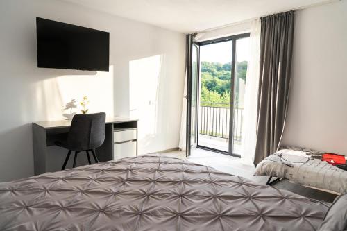 a bedroom with a bed and a desk and a window at Casa Andrei Guesthouse in Bărăşti