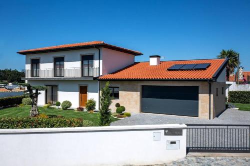 a house with a garage with a solar roof at Cosy Chalet in Várzea with Private Pool in Várzea