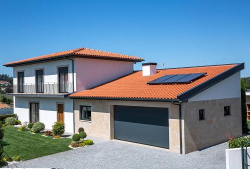 a house with solar panels on the roof at Cosy Chalet in Várzea with Private Pool in Várzea