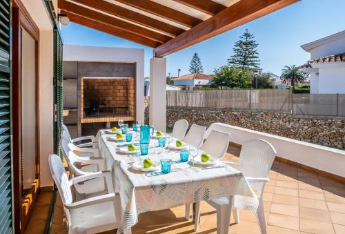 a table and chairs on a patio with a fireplace at Elegant Villa in Ciutadella de Menorca with Private Pool in Sa Caleta