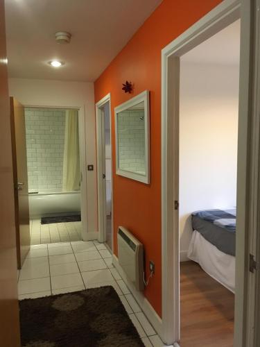 a room with an orange wall and a bedroom at QuickSpaces Heart of the City in Manchester