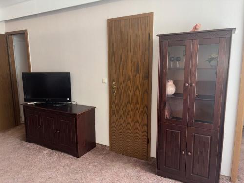 a room with a television and a wooden cabinet at Apartment 231 in Hohegeiß