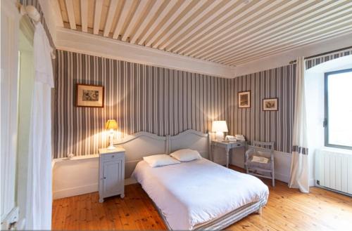 a bedroom with a bed and two tables and two lamps at Manoir majestueux à Satillieu avec piscine privée in Satillieu