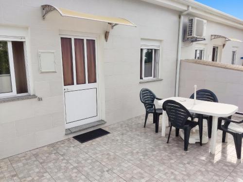 a patio with a table and chairs and a building at Comfortable House in Marinhas + Garden and Sea View. in Marinhas