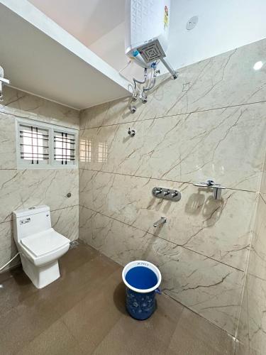 a bathroom with a toilet and a shower and a bucket at DM Bliss in Chikmagalūr