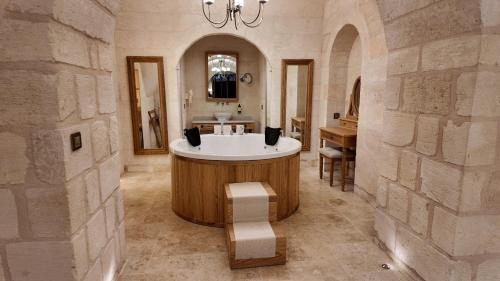 a bathroom with a sink and a tub in a room at Shamas Hotel in Midyat
