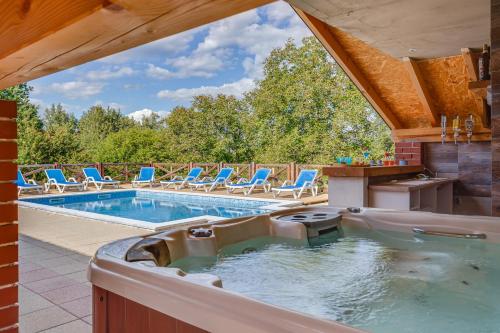 an outdoor swimming pool with chairs and a swimming tub at Peaceful Villa in Gornje Dubrave with Private Pool in Gornje Dubrave