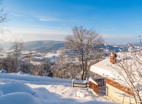 a snow covered roof of a house with a bench at Chalet charmant au Tholy avec piscine partagée in Le Tholy