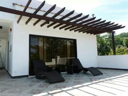 a patio with chairs and a table in a house at Sulu Sea Boutique Hotel in Boracay