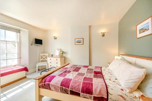 a bedroom with a bed and a dresser and a window at 1 Bed in Appledore oc-captv in Appledore