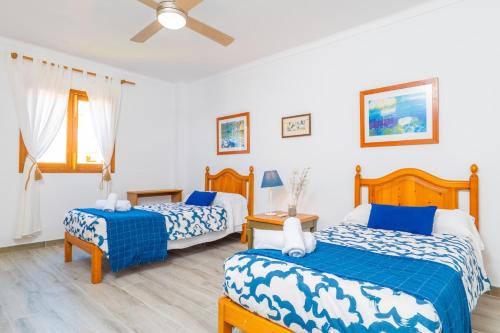 a bedroom with two beds and a ceiling fan at PDM CA'N NOFRE in Playa de Muro