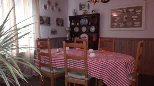 d'une salle à manger avec une table et un tissu de table rouge et blanc. dans l'établissement Le Champ Bouchon - Chambres d'hôtes, à Tréban