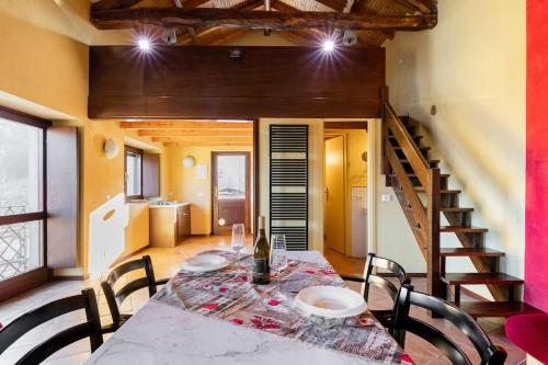 a dining room with a table and chairs and a staircase at Charming Villa with Private Pool in Vesime in Vesime