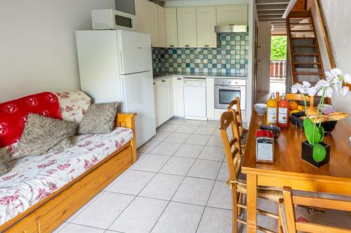 a kitchen with a couch and a table in a room at Appartement Douillet Saint-Sorlin-d'Arves 49 m² Vue montagne in Saint-Sorlin-dʼArves