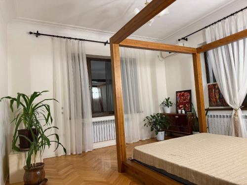 a bedroom with a bed in a room with windows at Просторный дом с садом in Qŭyliq