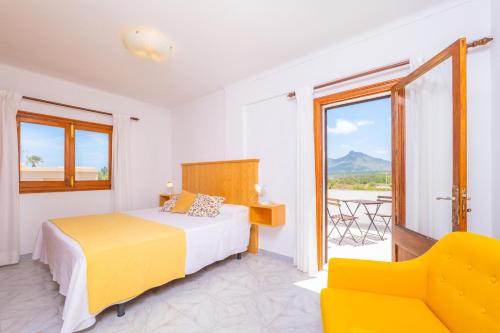 a bedroom with a bed and a couch and a window at Can Fusteret in Son Serra de Marina