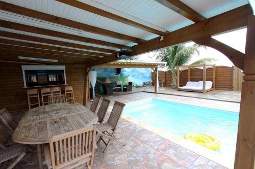 a patio with a table and a swimming pool at Villa élégante à Anse-Bertrand avec piscine in Anse-Bertrand