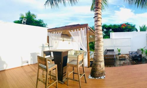 a patio with a table and chairs and a palm tree at Villa élégante à Anse-Bertrand avec piscine in Anse-Bertrand