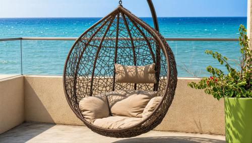 a hanging rattan chair on a balcony overlooking the ocean at Sea-View Villa with Infinity Pool Algiers in Tipaza