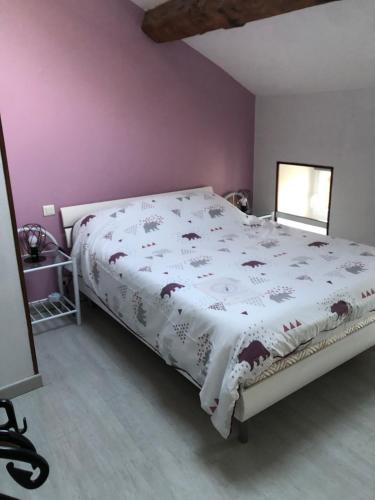 a bedroom with a large bed with a white comforter at Meublé lilas in Réaumur
