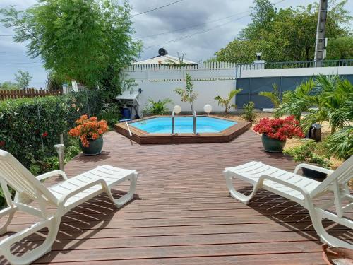a patio with two chairs and a swimming pool at Villa élégante à Bouillante avec piscine privée in Bouillante