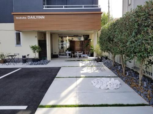 a walkway in front of a building with tables and chairs at Tsukuba Daily Inn in Tsukuba