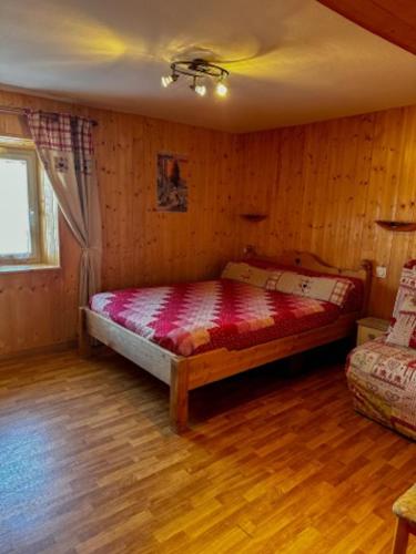 a bedroom with a bed in a room with wooden walls at Appartement confortable à Gérardmer 40 m² proximité pistes in Gérardmer