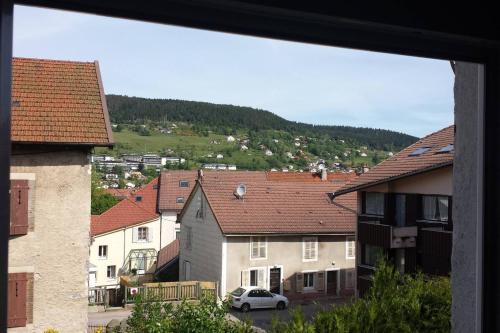 a view of a town with houses and a car at Appartement confortable à Gérardmer 40 m² proximité pistes in Gérardmer