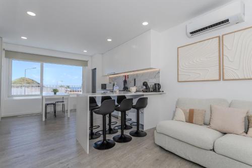 a kitchen and living room with a counter and a couch at GuestReady - Sea Apartments in São Roque