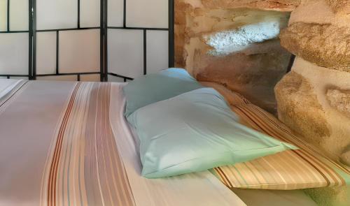 ein Bett mit zwei Kissen darauf in der Unterkunft Cozy studio with mountain view - 20 m² - Águeda in Urgueira