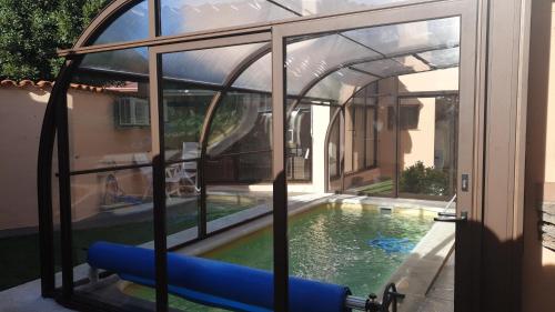 a swimming pool in a house with a glass enclosure at Charming villa in Pajares de la Lampreana with private pool in Pajares de la Lampreana