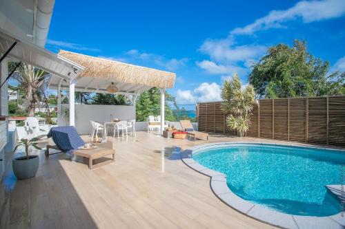 a patio with a swimming pool and a table and chairs at Villa spacieuse à Hyacinthe, Le Robert avec piscine privée in Le Robert