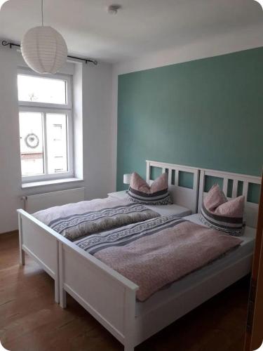 a bedroom with a white bed with pillows on it at Specht-Ferienwohnung-1-Tangermuende in Tangermünde