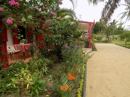 a garden with flowers on the side of a house at Comfortable Studio with Sea View in Foulpointe - 30 m² in Foulpointe