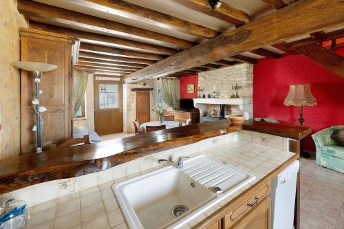 a kitchen with a sink and a red wall at Chez Pauline in Massangis