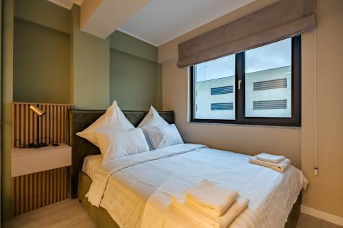 a bedroom with a bed with white sheets and a window at Own the Moment by Blvd 41B7 - Free Parking in Voluntari