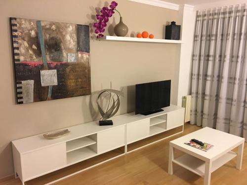 a living room with a white entertainment center at Spacious Apartment in Terrassa with Shared Pool, 85 m² in Terrassa