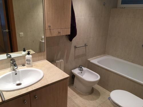 a bathroom with a sink and a toilet and a bath tub at Spacious Apartment in Terrassa with Shared Pool, 85 m² in Terrassa