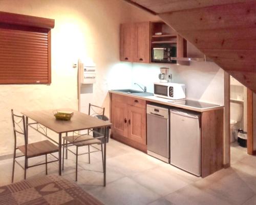 a small kitchen with a table and a microwave at Studio cosy à Saint-Jean-d'Arves 29 m² Vue montagne in Saint-Jean-dʼArves