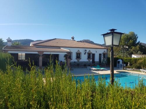a villa with a swimming pool and a house at Charming house in Arriate with private pool. in Arriate