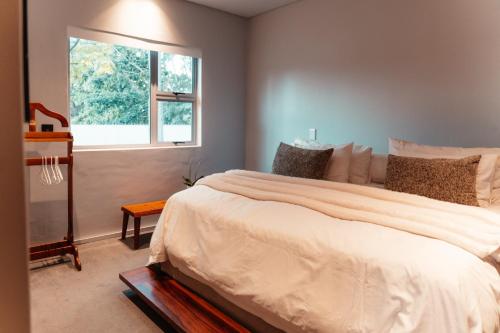 a bedroom with a large bed and a window at The Pool House in Gqeberha