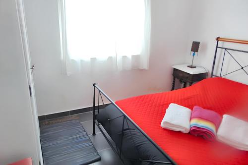 a red bed in a room with a window at Bright apartment in Almada with shared pool in Almada