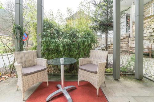 two chairs and a glass table on a patio at Comfortable apartment in Bad Schandau – 55 m² with garden terrace in Bad Schandau