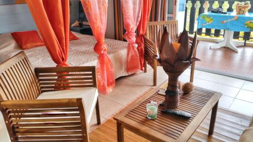 a living room with a table and two chairs and a couch at Studio confortable à Sainte-Anne 30 m² avec vue mer in Sainte-Anne