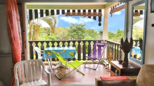 a balcony with two chairs and a pool on it at Studio confortable à Sainte-Anne 30 m² avec vue mer in Sainte-Anne
