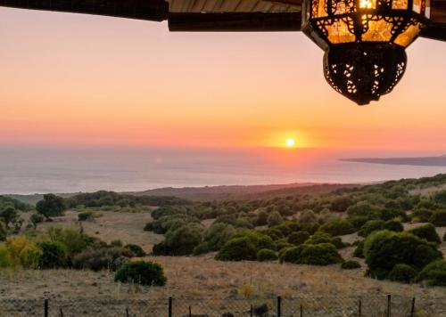 a chandelier hanging from a building with the sunset in the background at Charming House in El Chaparral in EL Chaparral